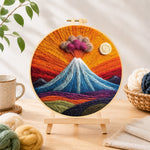 Finished erupting volcano with smoke clouds needle felting displayed on a wooden easel