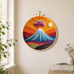 Erupting volcano with smoke clouds needle felt wall art displayed in a bright home interior
