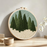Evergreen forest punch needle artwork displayed on a table