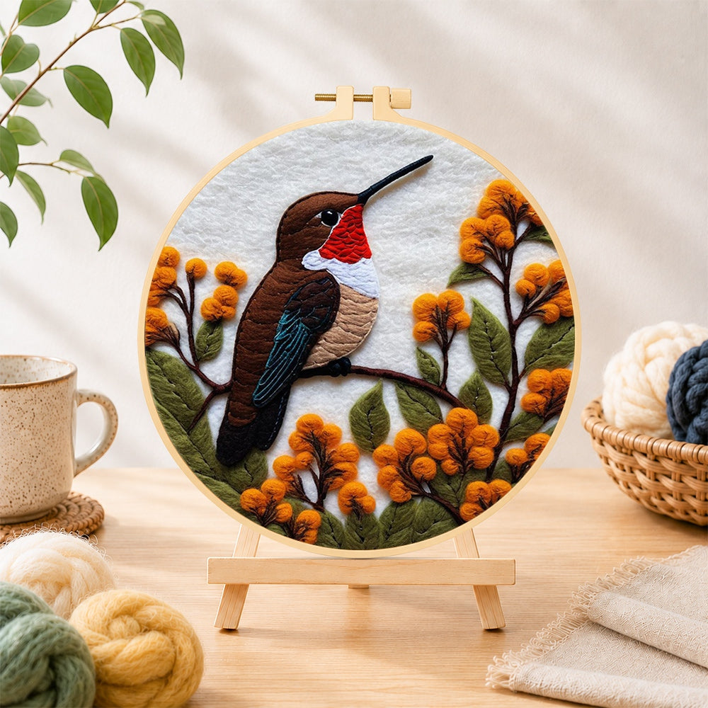 Finished exquisite ruby-throated hummingbird and autumn flowers needle felting displayed on a wooden easel