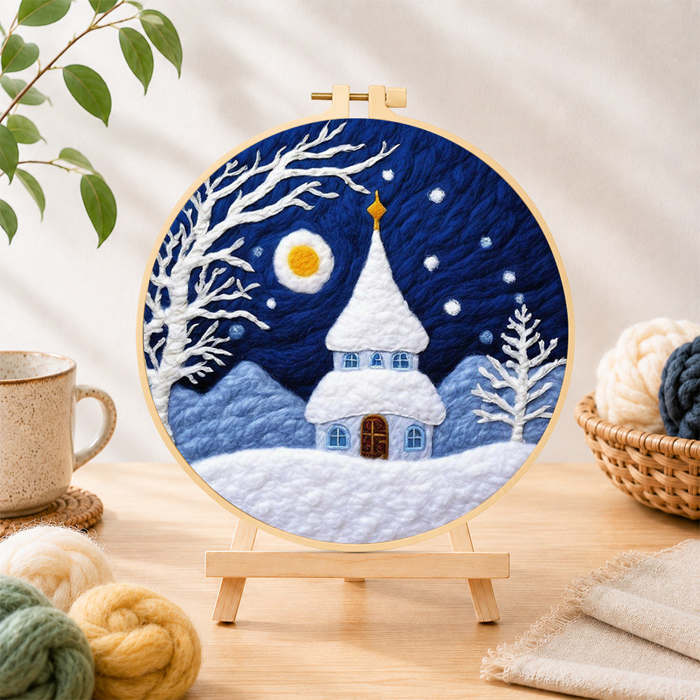 Finished fairy tale snowy spire cottage needle felting displayed on a wooden easel