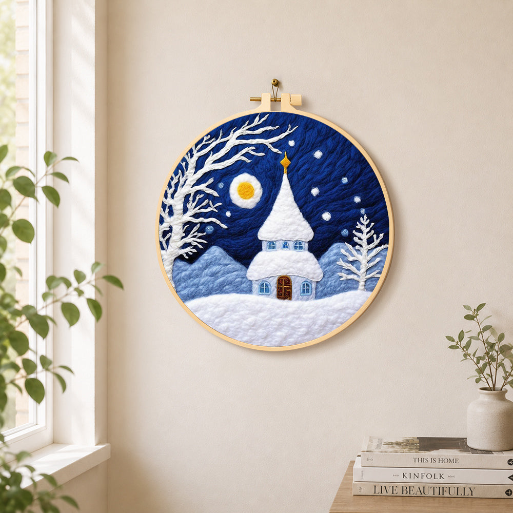 Fairy tale snowy spire cottage needle felt wall art displayed in a bright home interior