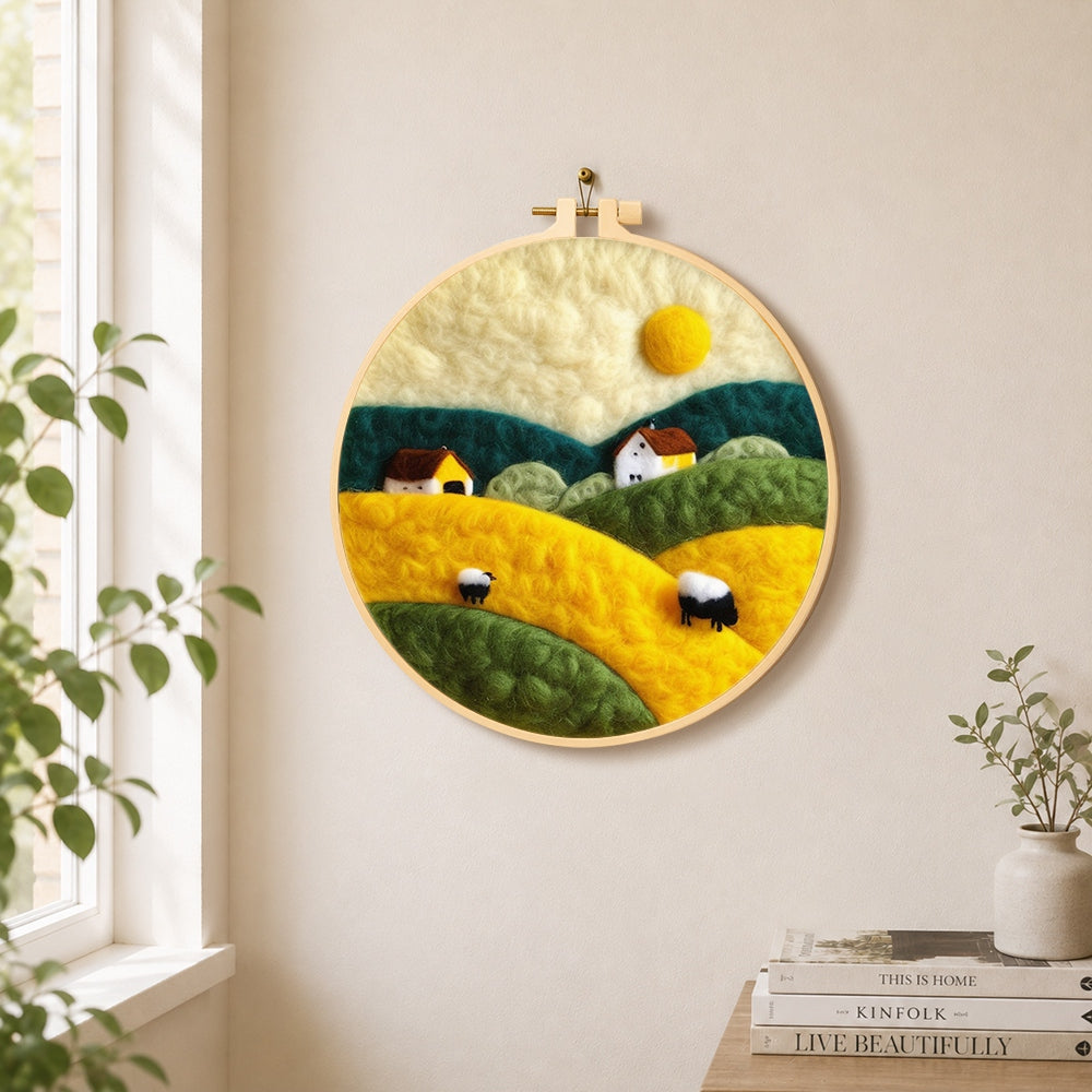 Farmhouses and rolling hills needle felt wall art displayed in a bright home interior