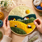 Creating the farmhouses and rolling hills wool painting by hand with a felting needle