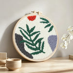 Fern leaf punch needle artwork displayed on a table