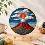 Finished fiery red volcano under the swirling sky needle felting displayed on a wooden easel