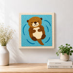 Finished floating happy otter artwork displayed on a wall