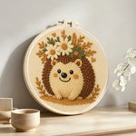 Floral crown hedgehog punch needle artwork displayed on a table