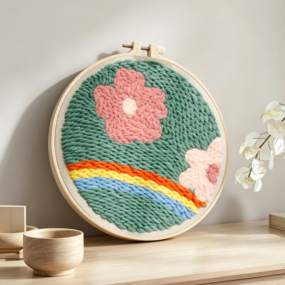 Floral meadow with rainbow punch needle artwork displayed on a table