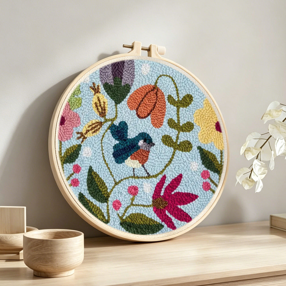 Flower vines and little bluebird punch needle artwork displayed on a table