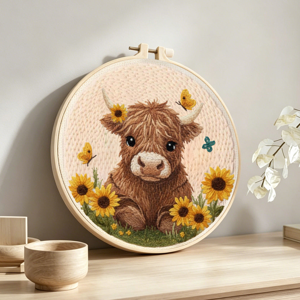Fluffy brown highland cow and sunflowers punch needle artwork displayed on a table