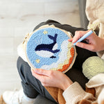 Creating handmade flying whale in sky with stars and clouds punch needle artwork
