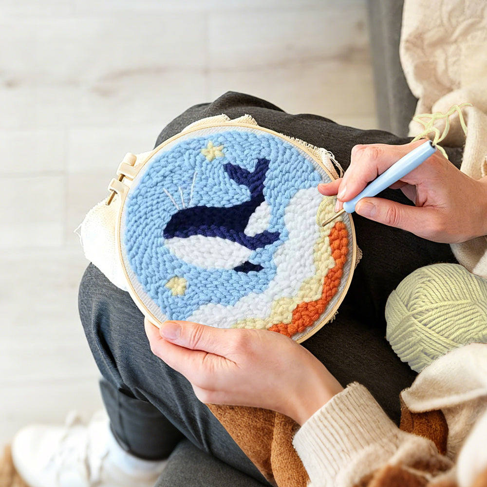 Creating handmade flying whale in sky with stars and clouds punch needle artwork