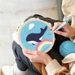 Creating handmade flying whale over rainbow in blue sky punch needle artwork