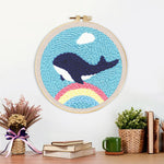 Finished flying whale over rainbow in blue sky artwork displayed on a wall