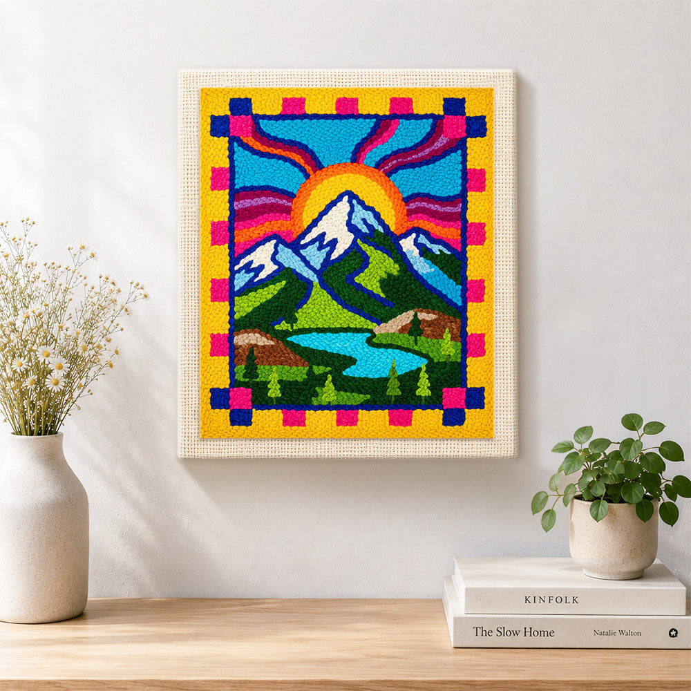 Finished folk art style mountains and sun rays artwork displayed on a wall
