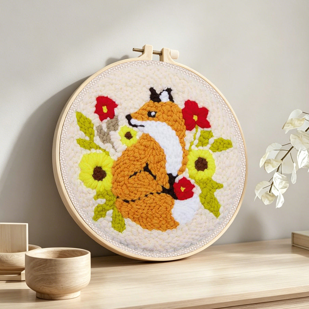 Fox and flowers punch needle artwork displayed on a table