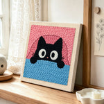 Funny peeking kitten punch needle artwork displayed on a table