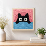 Finished funny peeking kitten artwork displayed on a wall
