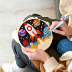Creating handmade galactic rocket and planets punch needle artwork