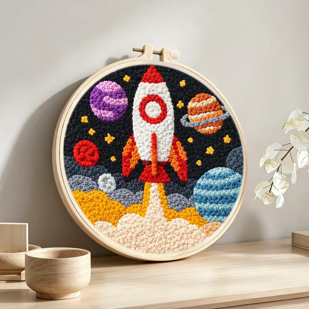 Galactic rocket and planets punch needle artwork displayed on a table