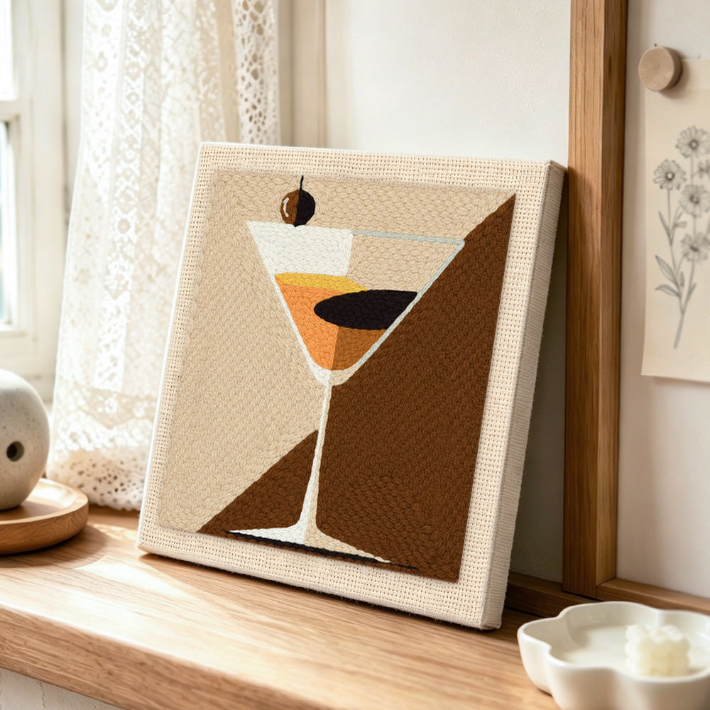 Geometric martini with olive punch needle artwork displayed on a table