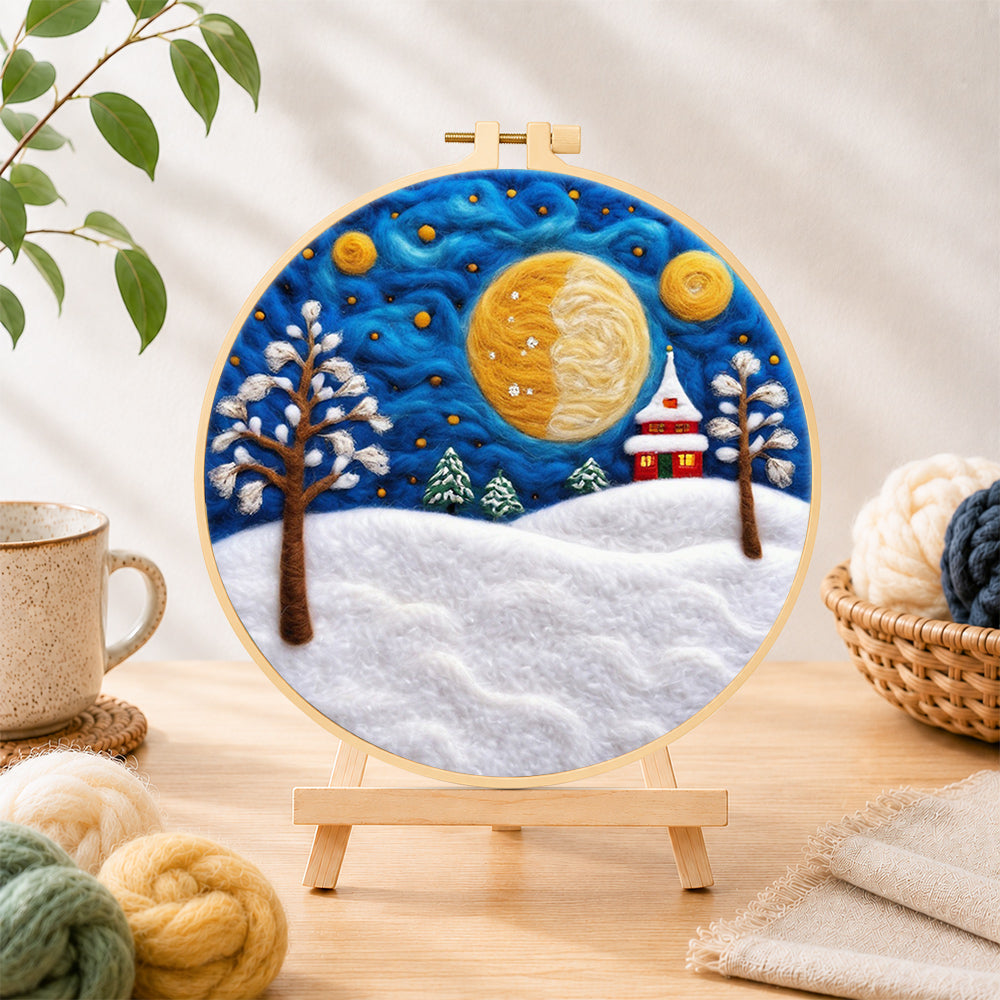 Finished giant spiral half-moon and snowy tower house needle felting displayed on a wooden easel