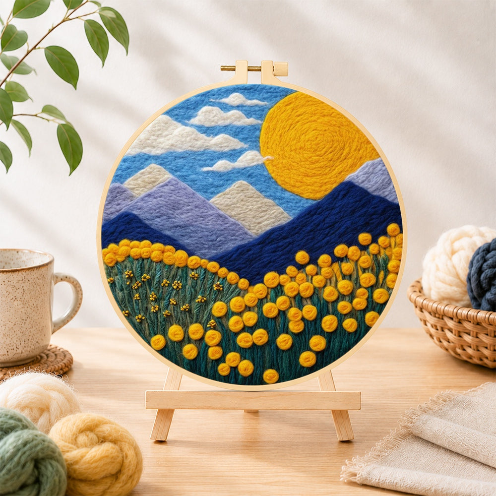 Finished giant sun, mountains and yellow flowers needle felting displayed on a wooden easel