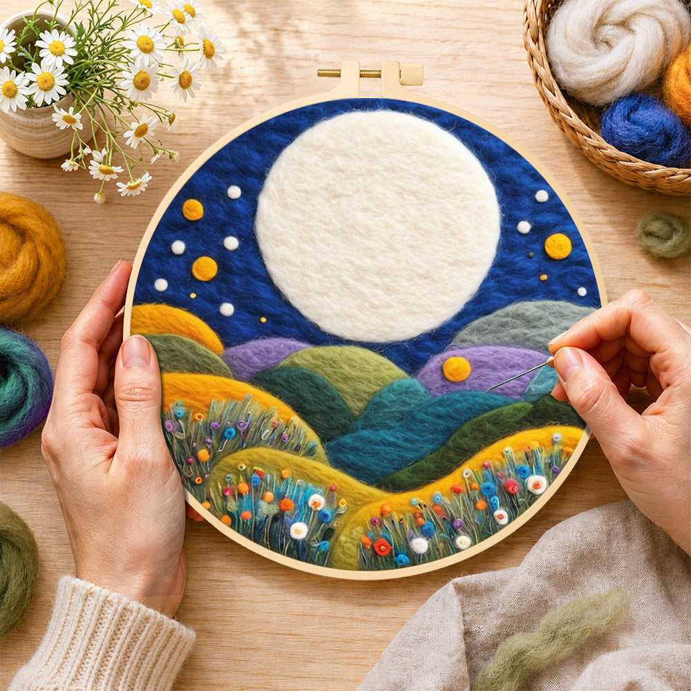 Creating the giant white moon over colourful flower hills wool painting by hand with a felting needle