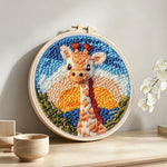 Giraffe at sunset punch needle artwork displayed on a table