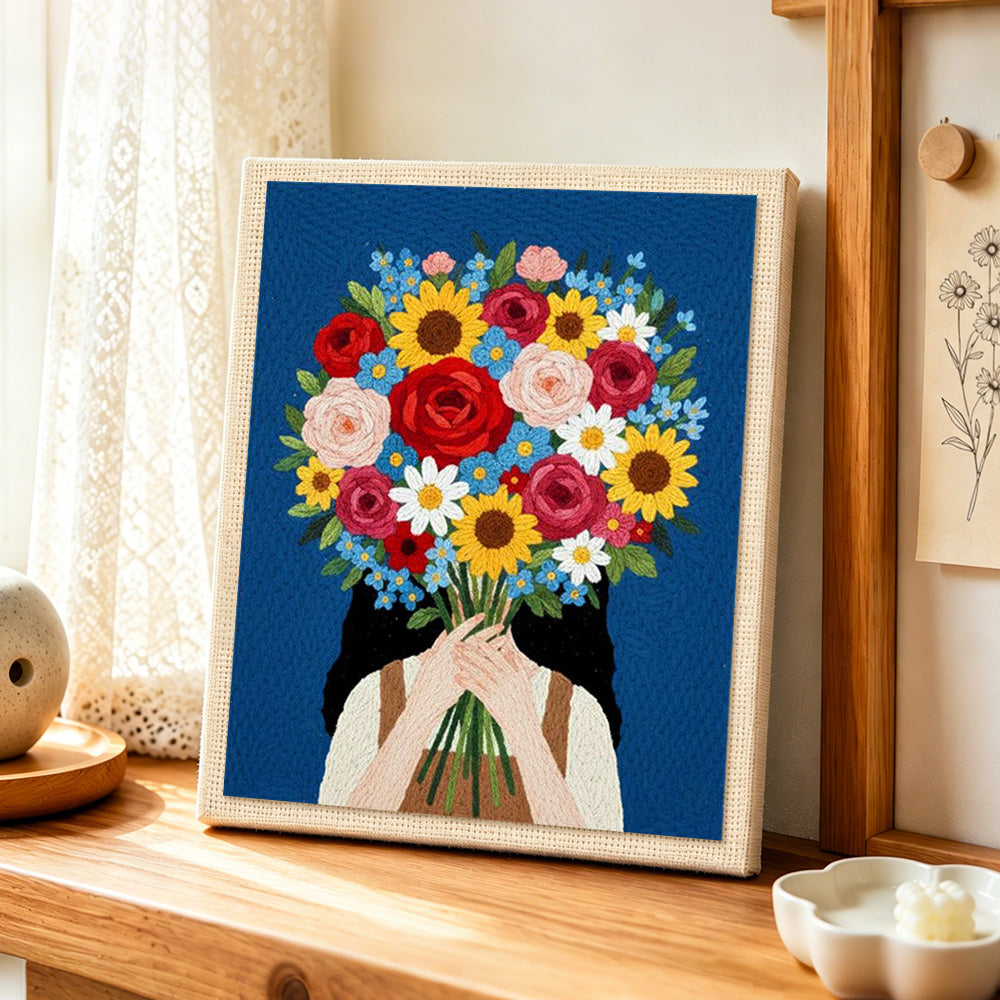Girl holding giant flower bunch punch needle artwork displayed on a table
