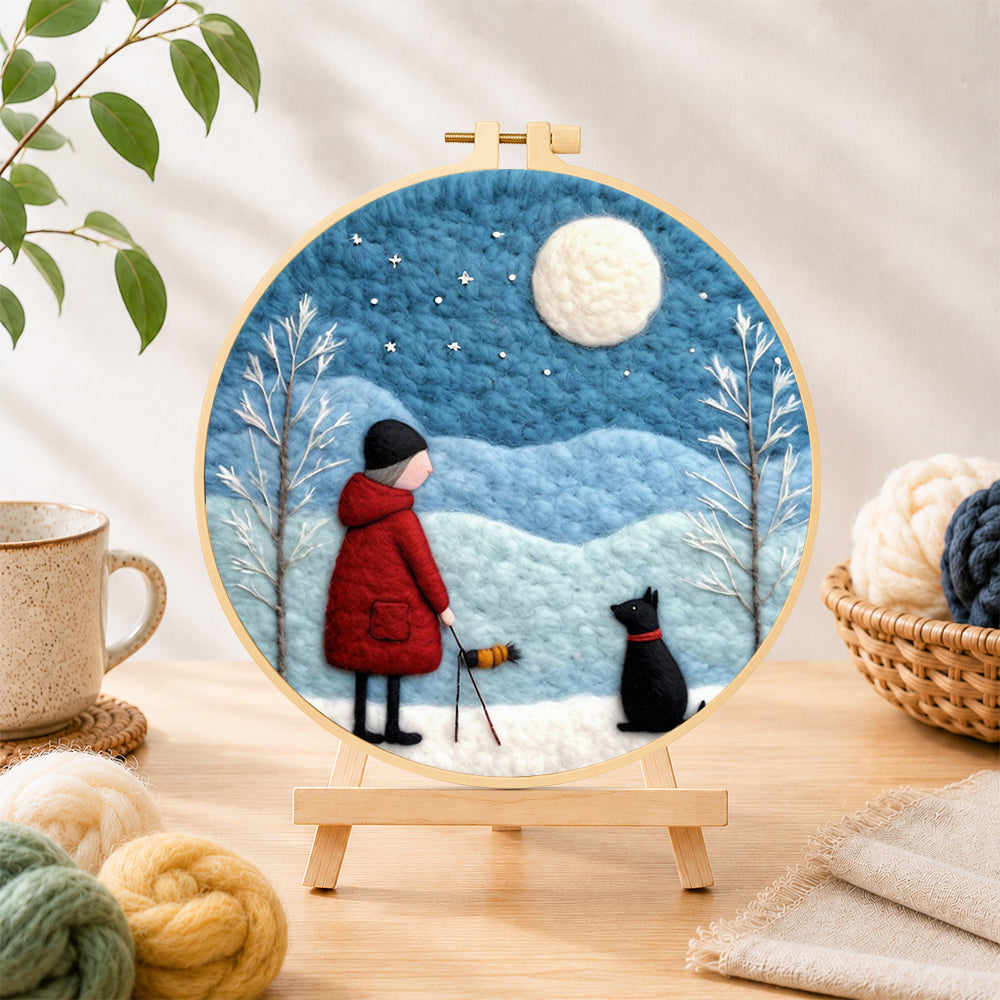 Finished girl in red coat walking black dog needle felting displayed on a wooden easel