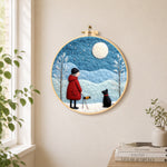 Girl in red coat walking black dog needle felt wall art displayed in a bright home interior