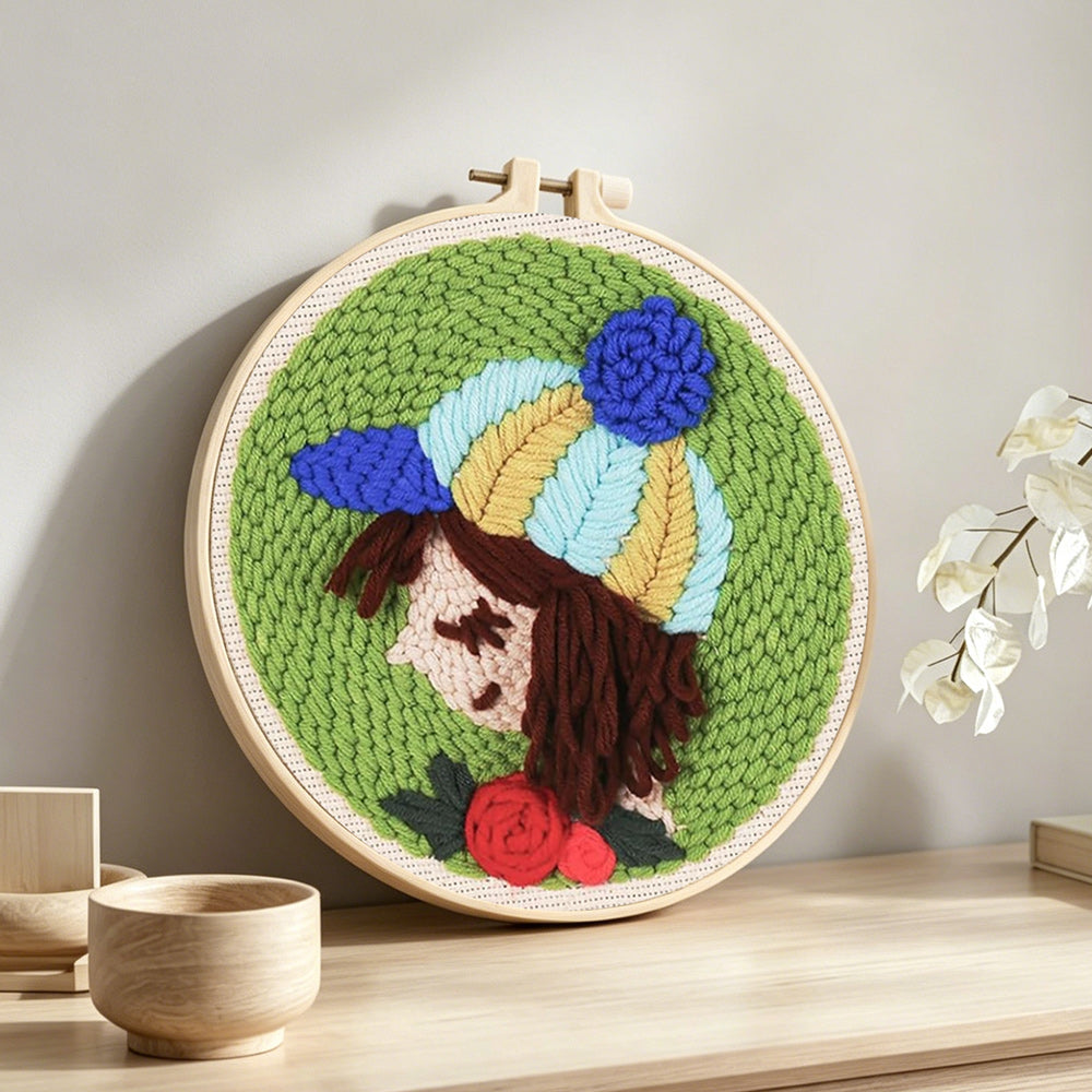 Girl with striped beanie and rose punch needle artwork displayed on a table