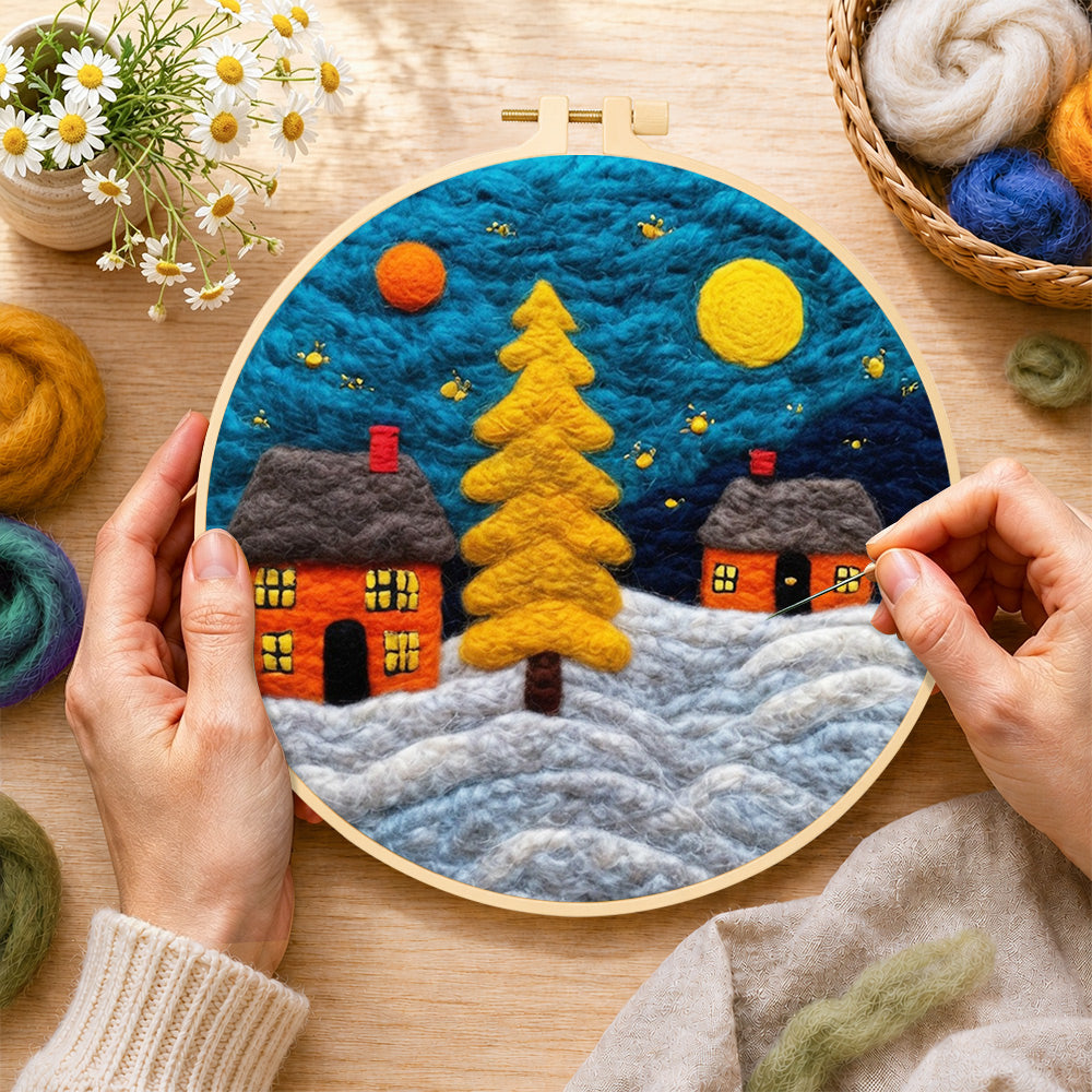 Creating the golden christmas tree and snowy cabins wool painting by hand with a felting needle