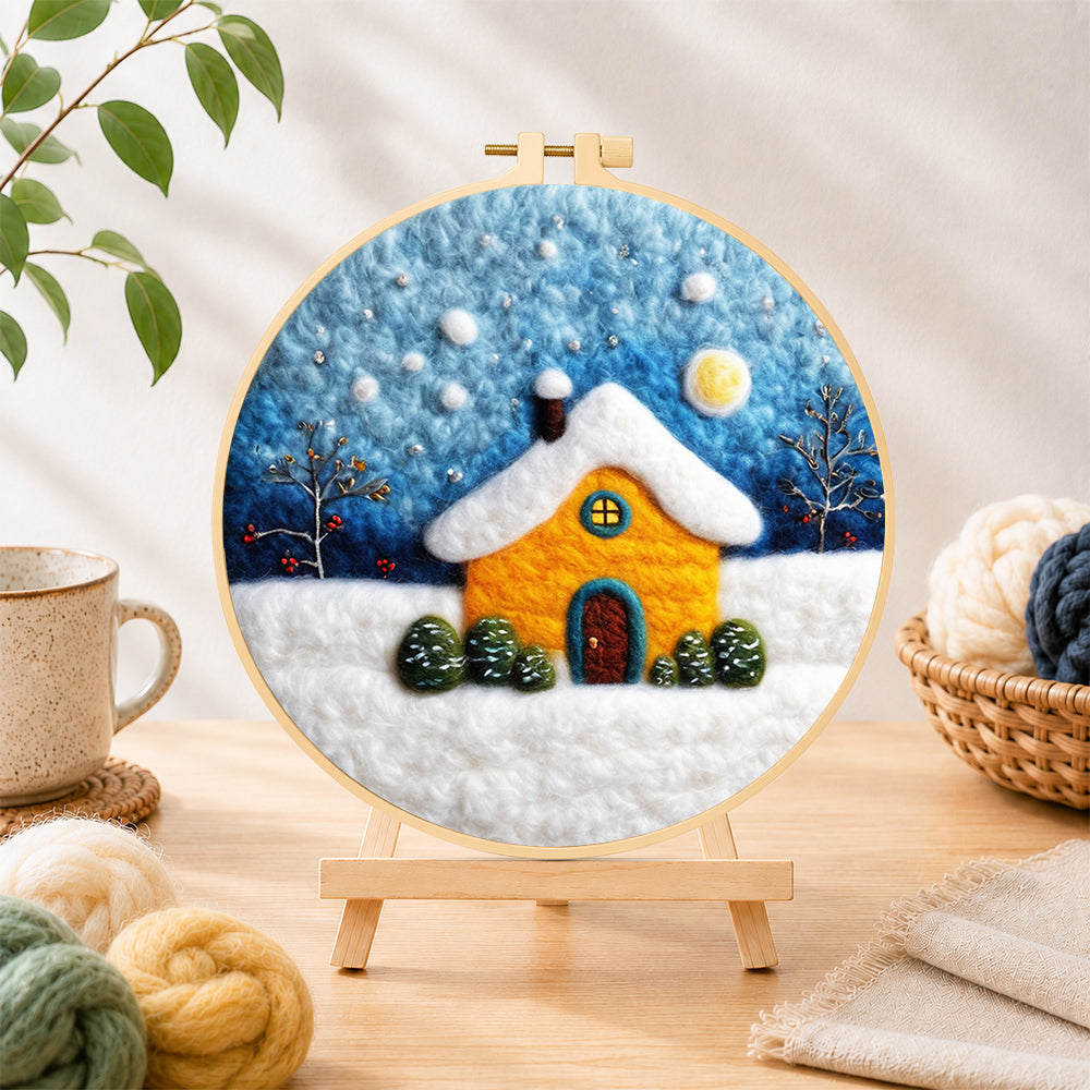 Finished golden snowy house under starry sky needle felting displayed on a wooden easel