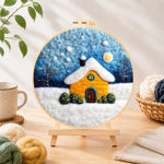 Finished golden snowy house under starry sky needle felting displayed on a wooden easel