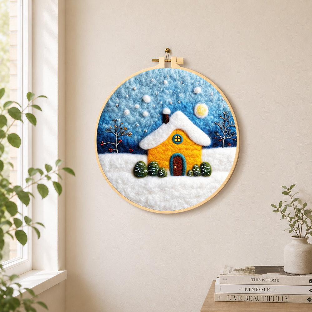 Golden snowy house under starry sky needle felt wall art displayed in a bright home interior