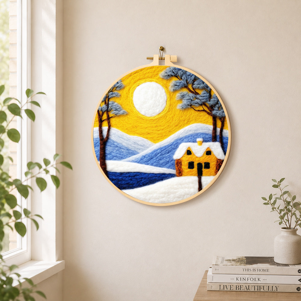 Golden sun and blue mountain snowscape needle felt wall art displayed in a bright home interior