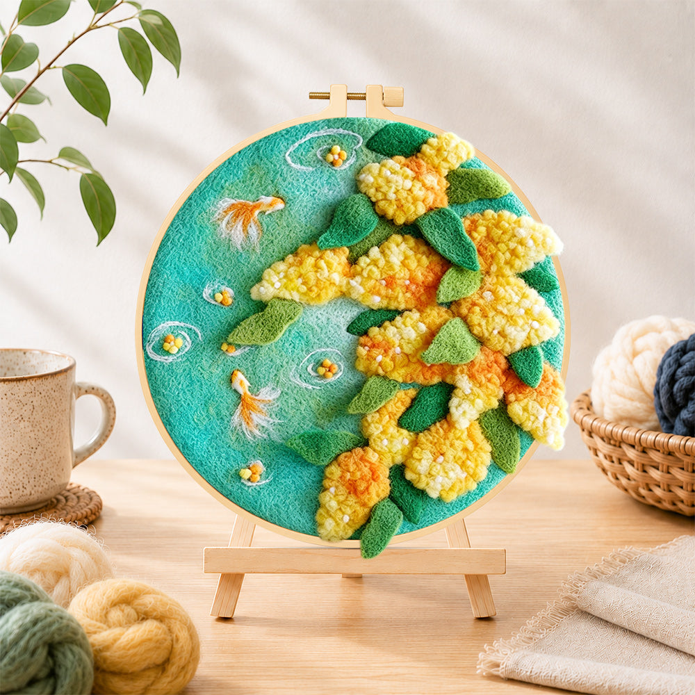 Finished goldfish with yellow plants needle felting displayed on a wooden easel