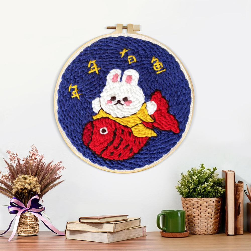 Finished good fortune bunny holding a koi fish artwork displayed on a wall