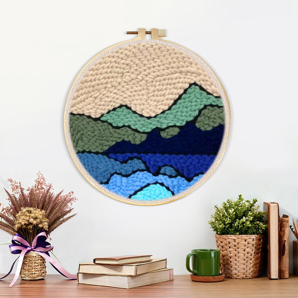 Finished green and blue mountain range artwork displayed on a wall