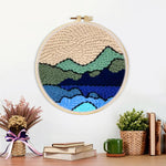 Finished green and blue mountain range artwork displayed on a wall