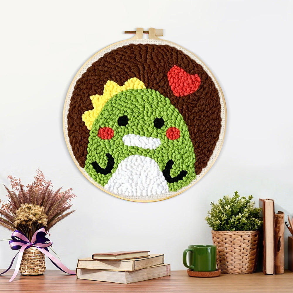 Finished green dinosaur and red heart artwork displayed on a wall