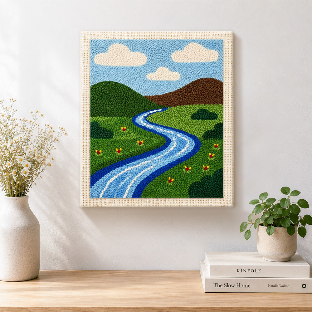Finished green grassland and peaceful river artwork displayed on a wall