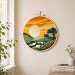 Green hills and fluffy sheep under golden sunset needle felt wall art displayed in a bright home interior
