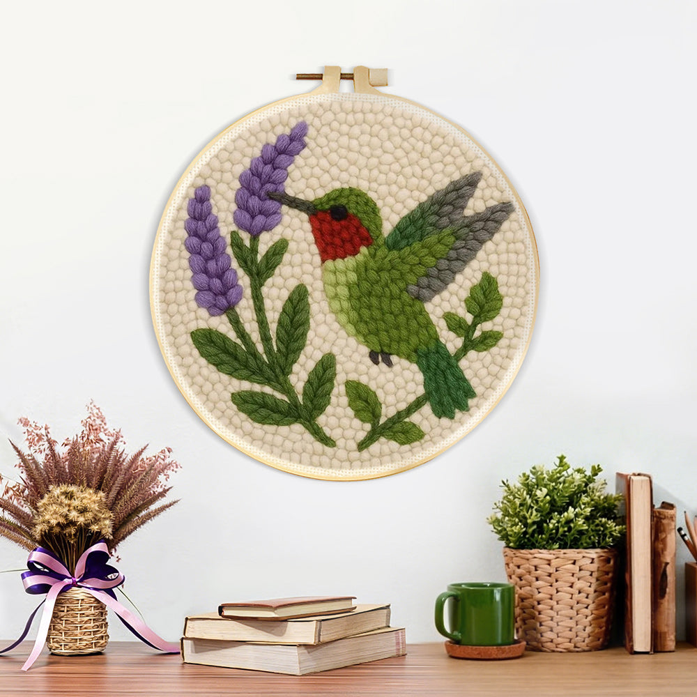 Finished green hummingbird and purple flower artwork displayed on a wall