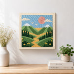 Finished green mountains and yellow wildflowers artwork displayed on a wall