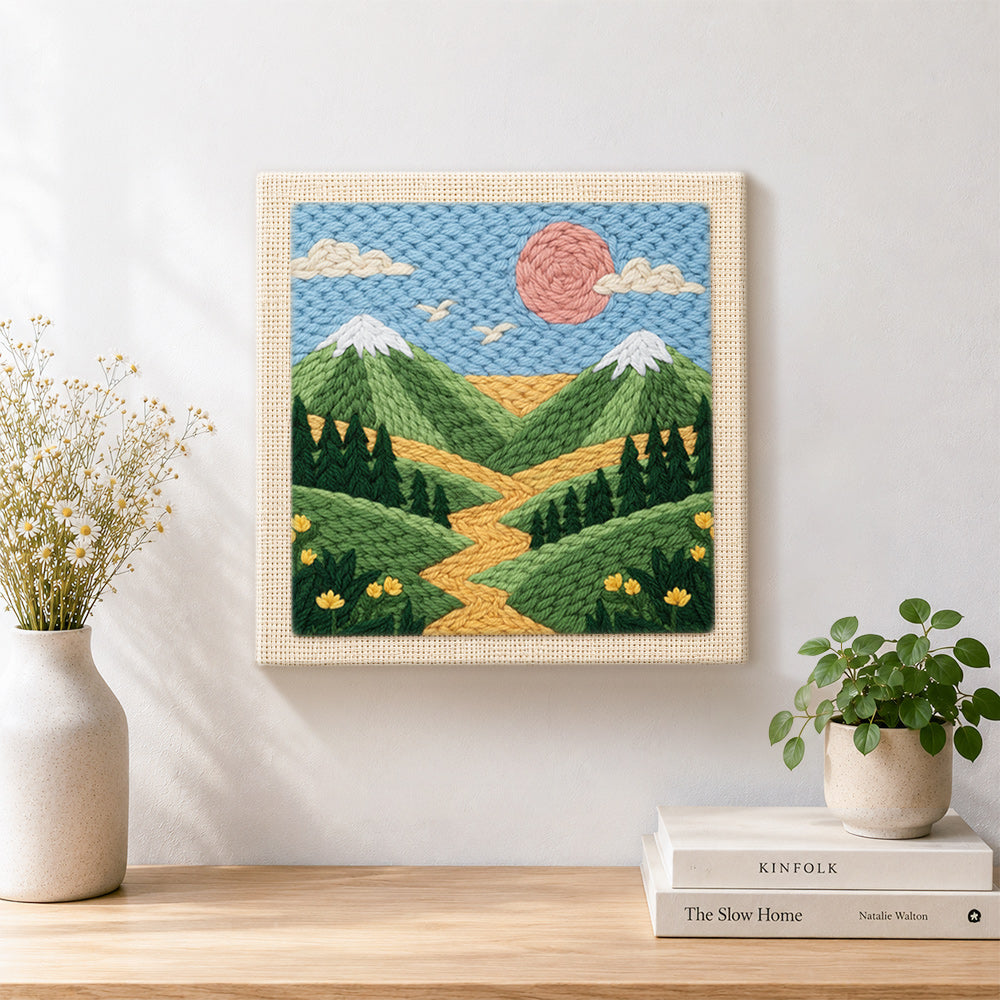 Finished green mountains and yellow wildflowers artwork displayed on a wall