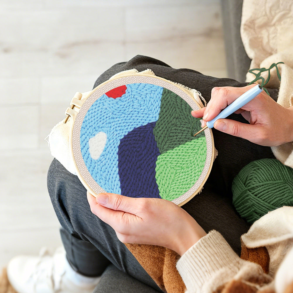 Creating handmade green mountains in spring punch needle artwork